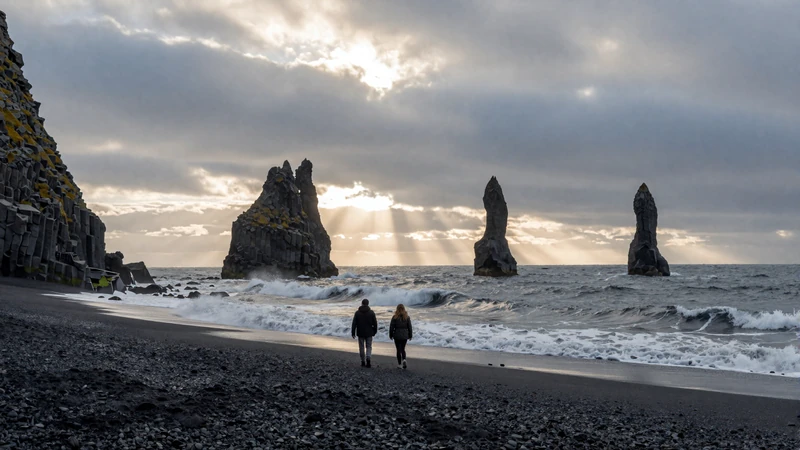 Couple walking on Reynisfjara black sand beach in Iceland - dramatic volcanic landscape dating experience